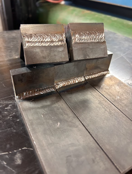 Replacement bracket assembly built up on the bench before installation, showing the finished fillet welds.
