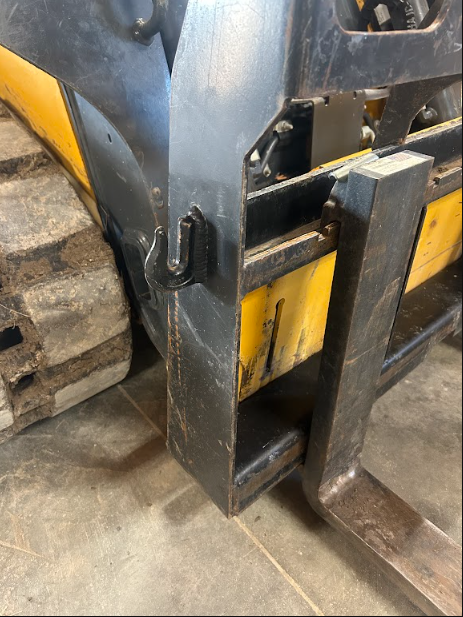 Fork carriage and attachment plate welded and fitted to a skid steer loader.