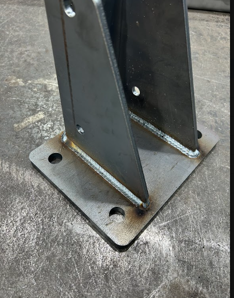 Post welded to a drilled base plate, fillet welds run out clean on both sides.