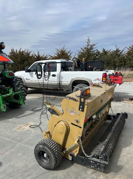 Agricultural implement repaired on site, with the welding truck and leads set up alongside it.